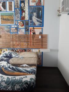 una camera da letto con una parete ricoperta di immagini di Fly B&B a Roma