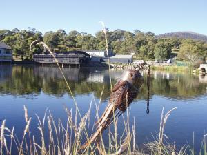 un barco sentado en medio de un lago en Novotel Lake Crackenback Resort, en Crackenback