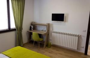 1 dormitorio con escritorio, ordenador y silla verde en Il Gatto Stanco B&B en Arona