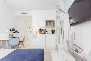 a small kitchen with white cabinets and a table at Skyreach BizzStay - Wohnen am Main in Frankfurt/Main +33 photos
