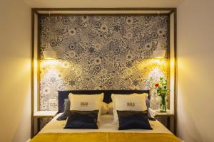Halo Boutique Hotel في إشبيلية: غرفة نوم بسرير كبير وبجدار