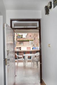 una porta aperta su un balcone con tavolo e sedie di Apartment in Nepal a Kathmandu