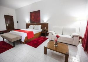 pokój hotelowy z łóżkiem i kanapą w obiekcie Hotel Praia w mieście São Tomé