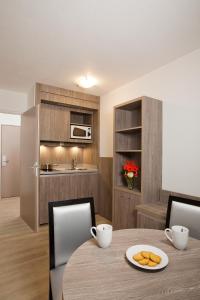 a kitchen with a table and a microwave at Séjours & Affaires Reims Clairmarais in Reims