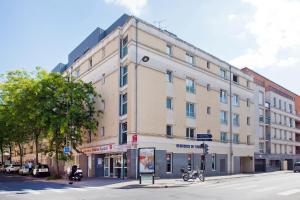 a large building on the corner of a street at Séjours & Affaires Reims Clairmarais in Reims