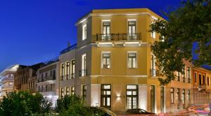 um edifício amarelo alto em frente a uma rua em Thission Luxury Homes & SPA by K&K em Atenas