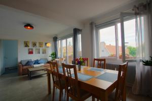 a dining room with a table and chairs and a couch at Au Berceau des Cigognes in Sélestat