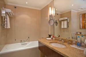 a bathroom with a sink and a tub and a mirror at Kharkiv Palace Hotel in Kharkiv