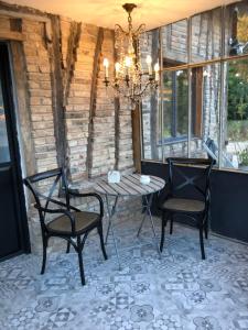un patio con mesa, 2 sillas y una lámpara de araña en B&B - Entre terre et mer, en Frettecuisse
