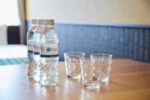 a bottle and two glasses on a wooden table at Rinn Gion Kenninji in Kyoto