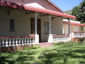 a house with a white fence and a porch at Dee's BnB in Pretoria