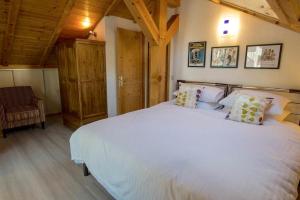 um quarto com uma grande cama branca e uma cadeira em Morgane Apartment em Chamonix-Mont-Blanc