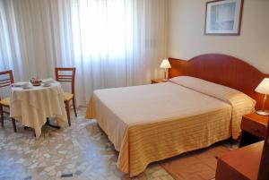 a hotel room with a bed and a table at Il Nocchiero City Hotel in Soverato Marina