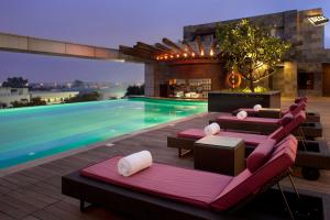 a pool with lounge chairs and a swimming pool at The Oterra in Bangalore