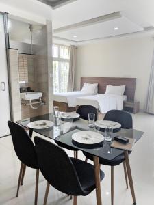 ein Esszimmer mit einem Tisch, Stühlen und einem Bett in der Unterkunft Clyford Suites in Bangalore