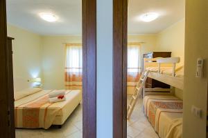 a room with two beds and a bunk bed at Le Residenze del Maria Rosaria - Vico Friuli 1 in Orosei