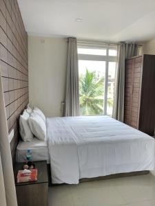 1 dormitorio con 1 cama grande y ventana en Clyford Suites, en Bangalore