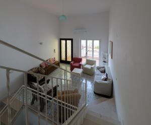 un soggiorno con pareti bianche e mobili bianchi di VILLA ISCLA maison d'hôtes a Ischia