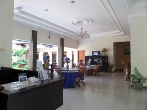 eine Lobby mit Leuten, die an einem Tisch in einem Zimmer sitzen in der Unterkunft Armi Hotel Malang in Malang