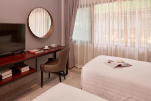 a hotel room with a bed and a desk and a television at W22 by Burasari in Bangkok