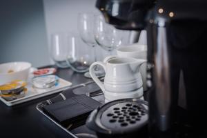 un bancone della cucina con lavandino, bollitore per tè e bicchieri di Lymm Boutique Rooms a Lymm