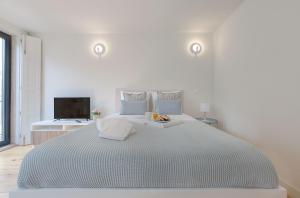 ポルトにあるDowntown Porto Flatの白いベッドルーム(大型ベッド1台、テレビ付)