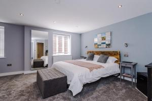 una grande camera da letto con un grande letto e uno specchio di Lymm Boutique Rooms a Lymm