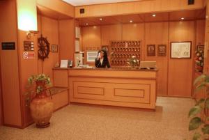 a woman talking on a cell phone at a counter at Il Nocchiero City Hotel in Soverato Marina