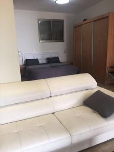 uma sala de estar com 2 camas e um sofá branco em Charmin apartment whit a big garden em Haifa