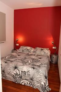 a bedroom with a bed with a red wall at Passeig De Gràcia Luxury in Barcelona