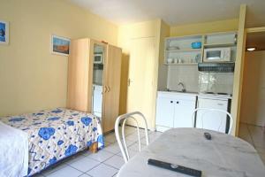 a kitchen and a bedroom with a bed and a table at Hotel Les Manguiers Jardin de l'Etat Centre Ville Parking Gratuit Canal Sat in Saint-Denis +7 photos