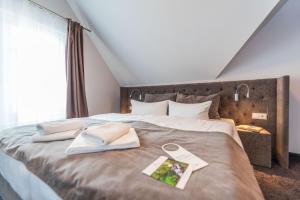 a bed with two towels and a book on it at Hotel Villa Belvedere in Binz