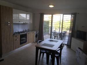 una cucina con tavolo e una cucina con balcone di Relax House a Nizza di Sicilia