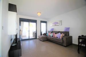 a living room with a couch and a television at Oasis Beach Gabriel in Orihuela Costa