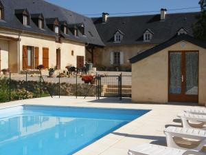 a swimming pool in front of a house at Gites de Bigorre in Cieutat