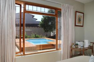una finestra con vista sulla piscina. di Coral Tree SelfCatering a St Francis Bay
