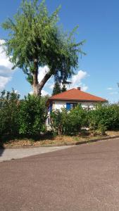 dom z drzewem przed ulicą w obiekcie Au Doubs Cocon Fleuri w mieście Mamirolle