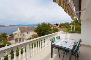 ein Balkon mit Tisch und Stühlen und Blick auf das Wasser in der Unterkunft Seaview Apartment Omisalj 3623-2 in Omišalj