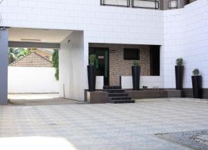 a white building with stairs and a doorway at Enka Flat Hotel in Abidjan