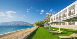 un hôtel sur la plage avec des chaises et l'océan dans l'établissement Hydroussa Skyros, à Skiros