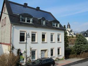 a white house with a black roof at Privatvermietung Gründel in Thermalbad Wiesenbad