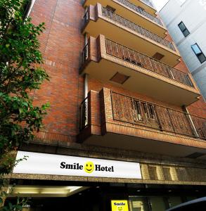 een gebouw met een glimlach hotel bord ervoor bij Smile Hotel Nihombashi Mitsukoshimae in Tokyo