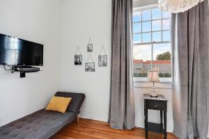 a living room with a couch and a flat screen tv at Modern Victorian House With Relaxing Courtyard in New Orleans