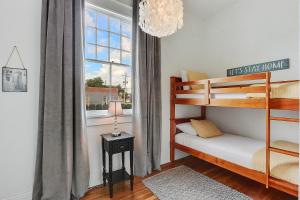 a bedroom with two bunk beds and a window at Modern Victorian House With Relaxing Courtyard in New Orleans