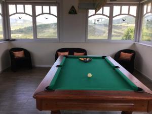 a pool table in a room with chairs and windows at 3 Bedroom Private floor in Luxury Mansion in Budapest