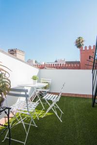 a patio with a table and chairs on a balcony at Apartamentos Boutique Vida in Seville