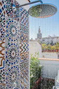 Habitación con una pared de mosaico y una ventana en Apartamentos Boutique Vida, en Sevilla