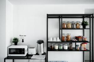 a black shelf with a microwave and some jars at Studio 41 Salaya-Sai4 in Nakhon Pathom
