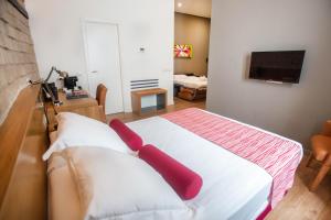 Un dormitorio con una cama con almohadas rojas. en Soho Boutique Capuchinos & Spa, en Córdoba