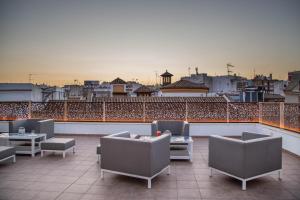 un patio en la azotea con sillas y mesas en un edificio en Soho Boutique Capuchinos & Spa en Córdoba